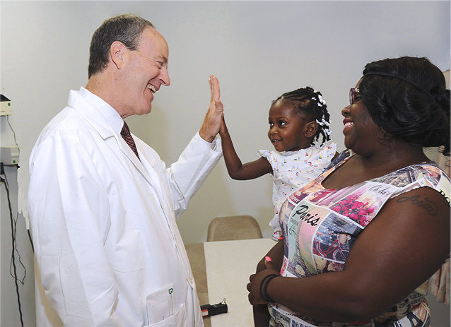 Photo: Dr. Doug Reich, Chairman, Family Medicine, with his patients, a mother and her child.